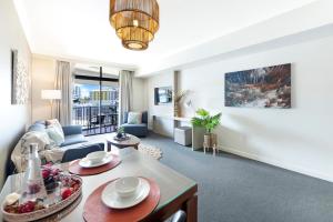 a living room with a couch and a table at King Suite Dreams - Poolside Living on the Esplanade in Darwin