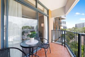 a balcony with a table and chairs on a balcony at King Suite Dreams - Poolside Living on the Esplanade in Darwin