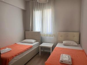 deux lits dans une petite pièce avec une fenêtre dans l'établissement Deka Evleri, à Izmir