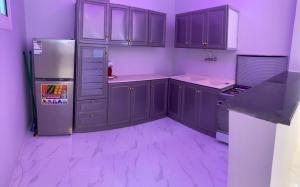 a kitchen with purple cabinets and a refrigerator at شاليه الجبل الاحمر 3 in AlUla