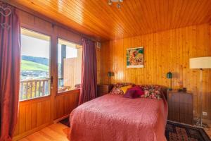 a bedroom with a bed and a large window at Hypercenter at the foot of the slopes in Le Grand-Bornand