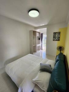 a bedroom with a large white bed with pillows at The Garden Emerald Avenue Cameron Highlands 6Pax 910 Wifi in Brinchang