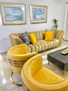 a living room with a couch and yellow pillows at The Oasis in Hartbeespoort