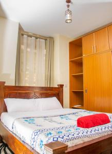 a bedroom with a bed with a red towel on it at Pearl Suites Apartments in Nakuru