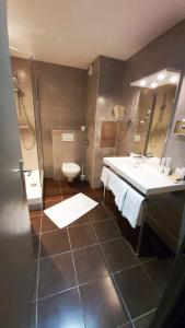 La salle de bains est pourvue d'un lavabo et de toilettes. dans l'établissement Hôtel 1er Consul Rouen, à Rouen