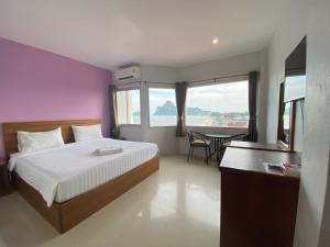 a bedroom with a bed and a table with a view at Prachuap Beach Hotel in Prachuap Khiri Khan