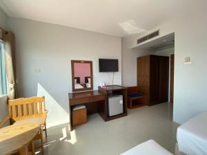 a bedroom with a desk with a mirror and a tv at Prachuap Beach Hotel in Prachuap Khiri Khan