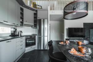 a kitchen with a black table and black chairs at Holiday in Lapland - Levihovi 6C in Levi