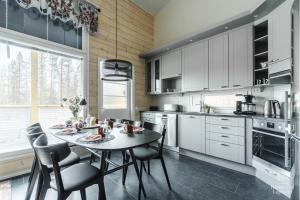 a kitchen with white cabinets and a table and chairs at Holiday in Lapland - Levihovi 6C in Levi