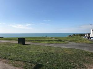 a path next to a field with the ocean at Apartment with own entrance & terrace on West Hill in Hastings