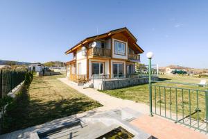 ein Haus mit einem Zaun davor in der Unterkunft AMAZING view, privacy and comfort - Villa Krasi in Blagoewgrad