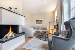 ein Wohnzimmer mit einem Kamin und einem Sofa in der Unterkunft Ferienhaus Finoah - Leben, Luxus, Leichtigkeit hinter der Duene in Westerland Sylt in Westerland