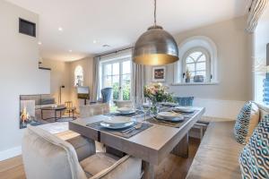 een eetkamer en een woonkamer met een tafel en stoelen bij Ferienhaus Finoah - Leben, Luxus, Leichtigkeit hinter der Duene in Westerland Sylt in Westerland