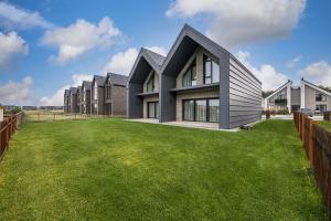 a house with a green lawn in front of it at Sea House 2N in Palanga