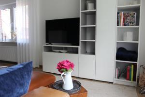 a living room with a tv and a vase with flowers at Ferienwohnung "Moi Tied" 35222 in Hesel