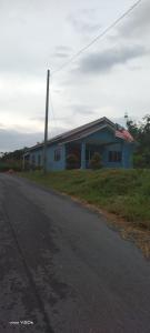 uma casa com uma bandeira americana no lado de uma estrada em HOMESTAY KAKMAH em Jasin