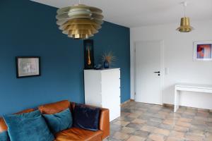 a living room with a couch and a blue wall at Ferienwohnung "Moi Tied" 35222 in Hesel