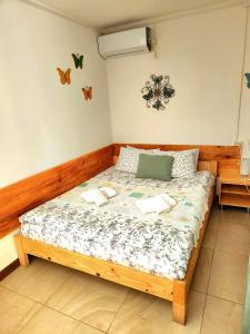 a bedroom with a bed in a room with butterflies on the wall at House & Yard Sesil XS 60m to beach in Ureki