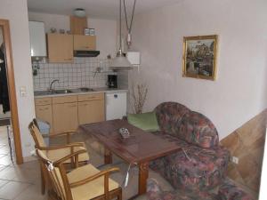 un soggiorno con tavolo e sedia e una cucina di Ostsee Bungalow mit Kamin & Terrasse a Ostseebad Koserow