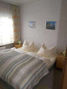 una camera d'albergo con un letto con cuscini bianchi di Ostsee Bungalow mit Kamin & Terrasse a Ostseebad Koserow