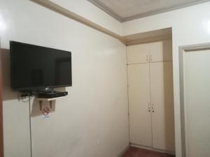 a living room with a flat screen tv on the wall at RedDoorz at Casa Marabella Villamonte Bacolod City in Bacolod