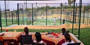 a group of people sitting at tables watching a baseball game at Il Casale Di Roma in Prima Porta