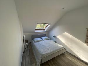 um pequeno quarto com uma cama e uma janela em Station House - Maison entre Disneyland et Paris em Roissy-en-Brie