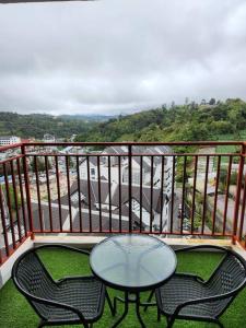 ブリンチャンにあるSweet Home Emerald Avenue Cameron Highlands 10Pax G12 Wifiのテーブルと椅子2脚、景色を望むバルコニー