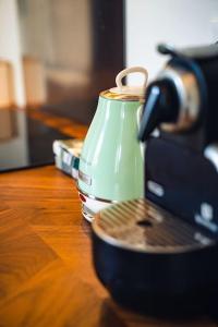 um bule de chá sentado numa mesa de madeira ao lado de uma máquina de café em Casa N em Arona