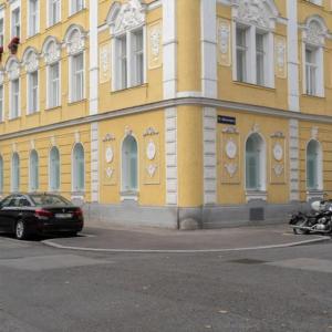 a yellow building with a car parked in front of it at Levestate Apartments Klährgasse Vol 1 in Vienna