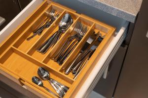 a wooden drawer with silver utensils in it at Levestate Apartments Klährgasse Vol 1 in Vienna