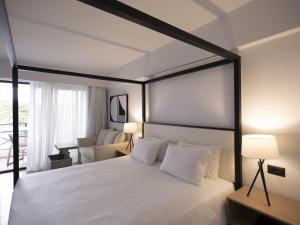 a bedroom with a white bed with a black frame at Hersonissos Palace in Hersonissos