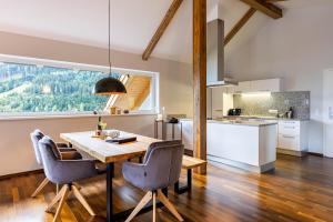 eine Küche und ein Esszimmer mit einem Tisch und Stühlen in der Unterkunft der Sonnberg - Alpinlodges in Zell am See