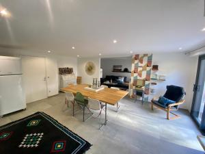 a kitchen and living room with a wooden table and chairs at Station House - Maison entre Disneyland et Paris in Roissy-en-Brie