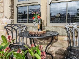 a table with two chairs and a wine glass on it at Tynedale in Padiham