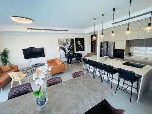 לביא אילת lavie eilat في إيلات: مطبخ وغرفة معيشة مع طاولة وكراسي