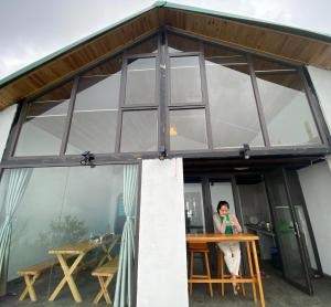 a woman standing in the front of a glass house at Bungalow view fanxipang 1579 Sa Pa in Sa Pa
