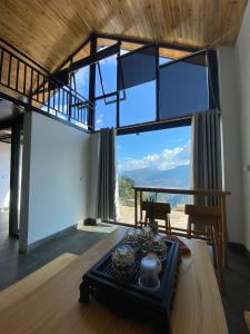 a living room with a table and a large window at Bungalow view fanxipang 1579 Sa Pa in Sa Pa