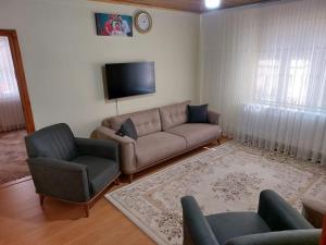 - un salon avec un canapé et une télévision dans l'établissement in the village, with a garden, one floor, detached, à Silivri