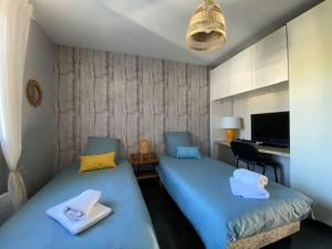 duas camas num quarto com lençóis azuis em Magnifique Maison Piscine Andernos sur le Bassin d'Arcachon ! em Andernos-les-Bains