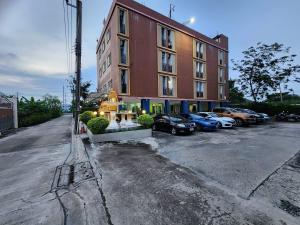 a building with cars parked in a parking lot at Psm at Donmueng in Ban Don Muang