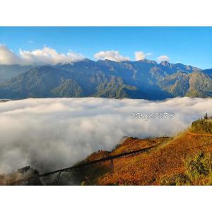 a group of mountains with clouds in the valley at Bungalow view fanxipang 1579 Sa Pa in Sa Pa