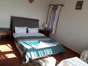 a hotel room with two beds and a chair at Drala Resort Nepal in Kathmandu