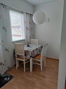 a dining room table with two chairs and a lamp at Parviainen-Helppoa yöpymistä in Soini