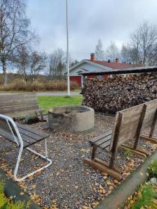 two benches and a fire pit in a yard at Parviainen-Helppoa yöpymistä in Soini