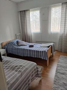 a bedroom with two beds and two windows at Parviainen-Helppoa yöpymistä in Soini