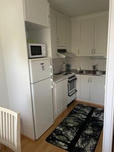 a kitchen with white cabinets and a white refrigerator at Parviainen-Helppoa yöpymistä in Soini