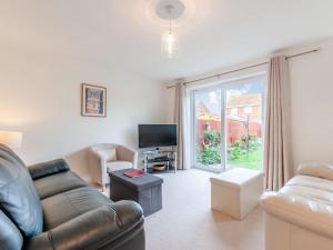 a living room with a couch and a television at Turnstone House in Birchington