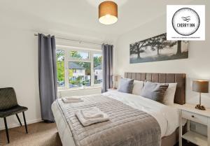 um quarto com uma cama, uma secretária e uma janela em Large 3 Bedroom House with Parking & Garden by Cherry Inn Short Let's & Services Accomodation em Cambridge