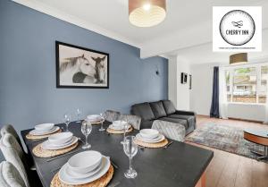 ein Wohnzimmer mit einem Tisch und einem Sofa in der Unterkunft Large 3 Bedroom House with Parking & Garden by Cherry Inn Short Let's & Services Accomodation in Cambridge